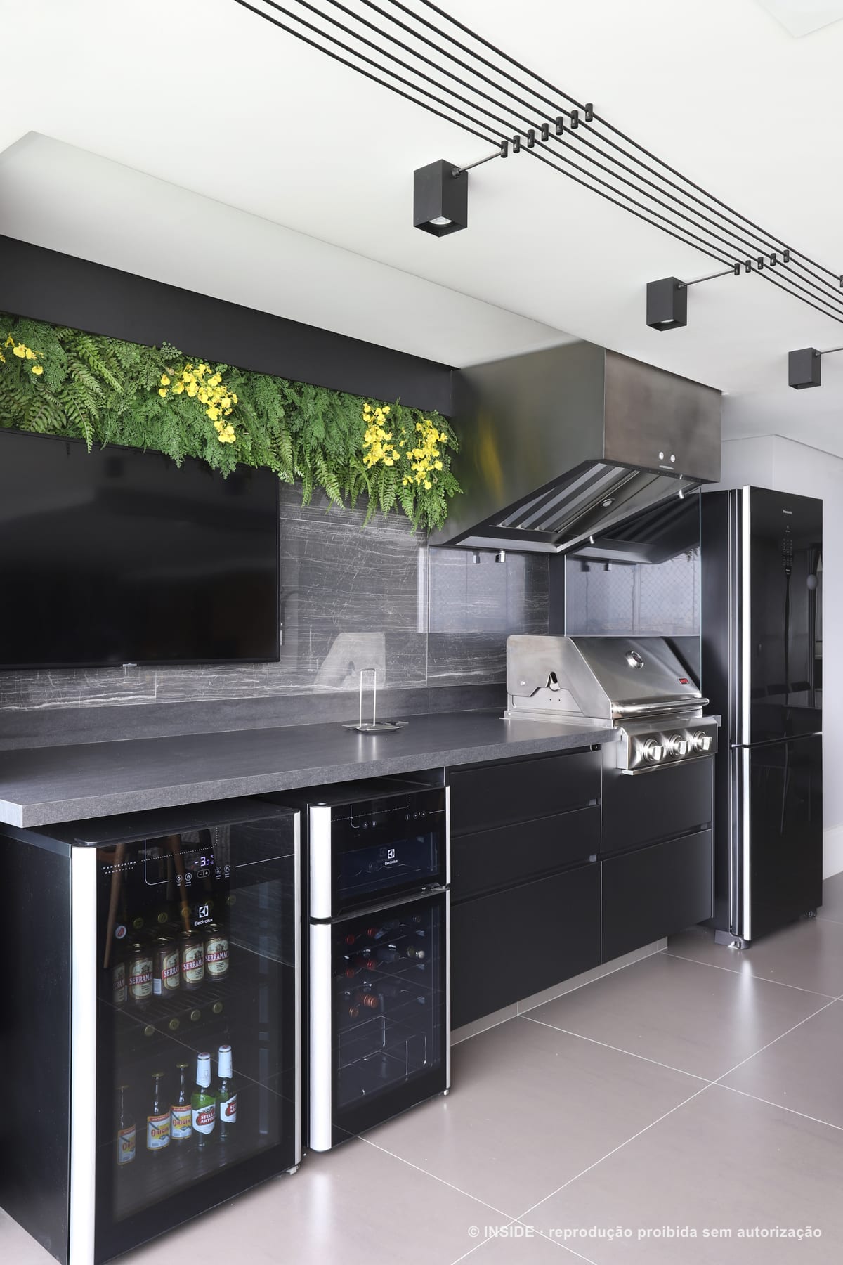 Área gourmet com churrasqueira de inox embutida, bancada de granito escuro e jardim vertical acima, apartamento Perdizes-DB, foto Mariana Orsi, acervo INSIDE