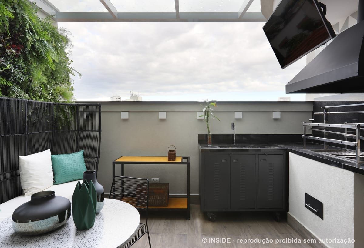 Terraço gourmet com bancada de granito preto, coifa, churrasqueira e o horizonte da cidade ao fundo, Vila Monumento-FC, foto Mariana Orsi, acervo INSIDE
