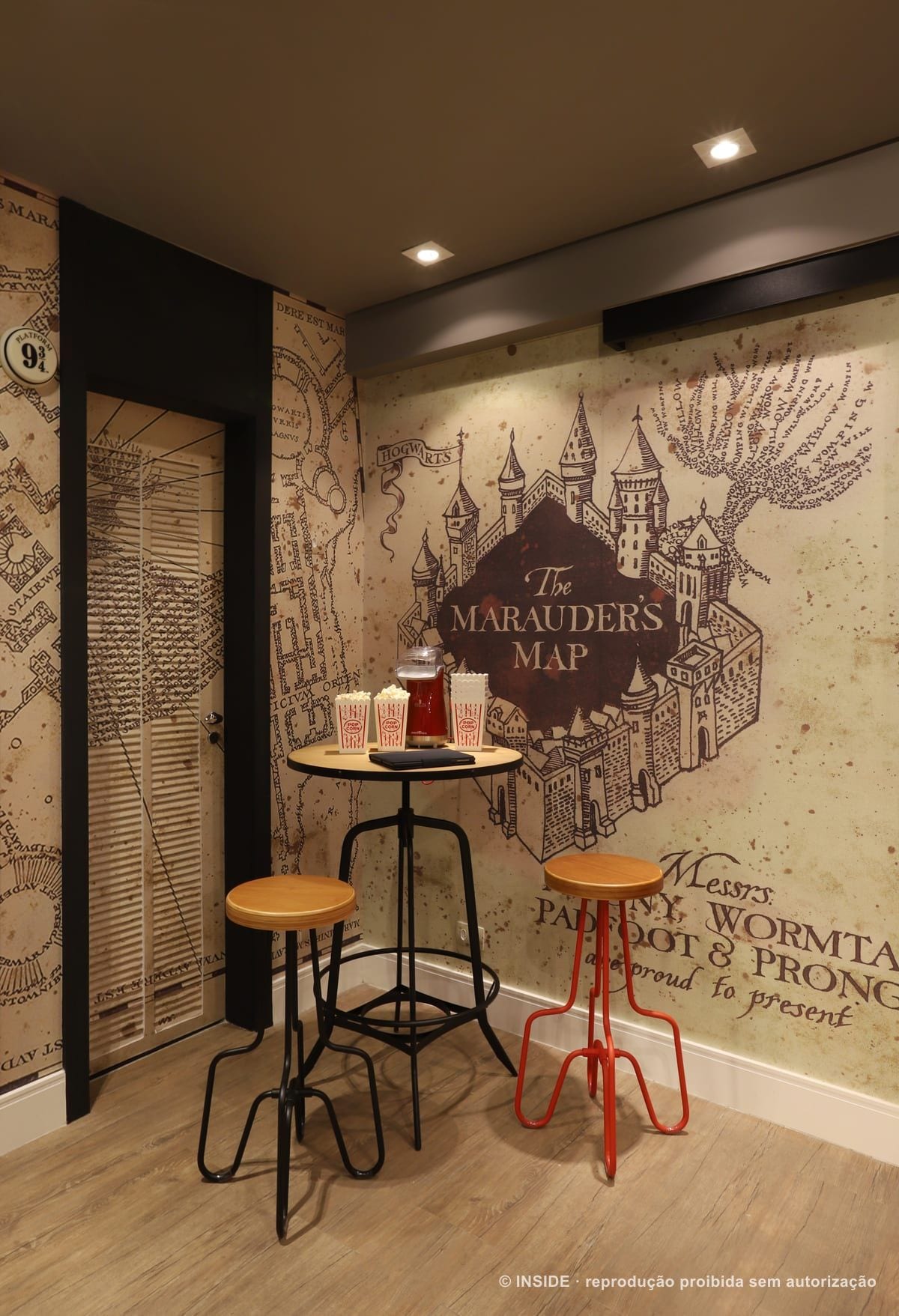 Parede revestida com o mapa de pergaminho do universo Harry Potter, ao lado de mesa alta com banquetas, Vila Monumento-FC, foto Mariana Orsi, acervo INSIDE