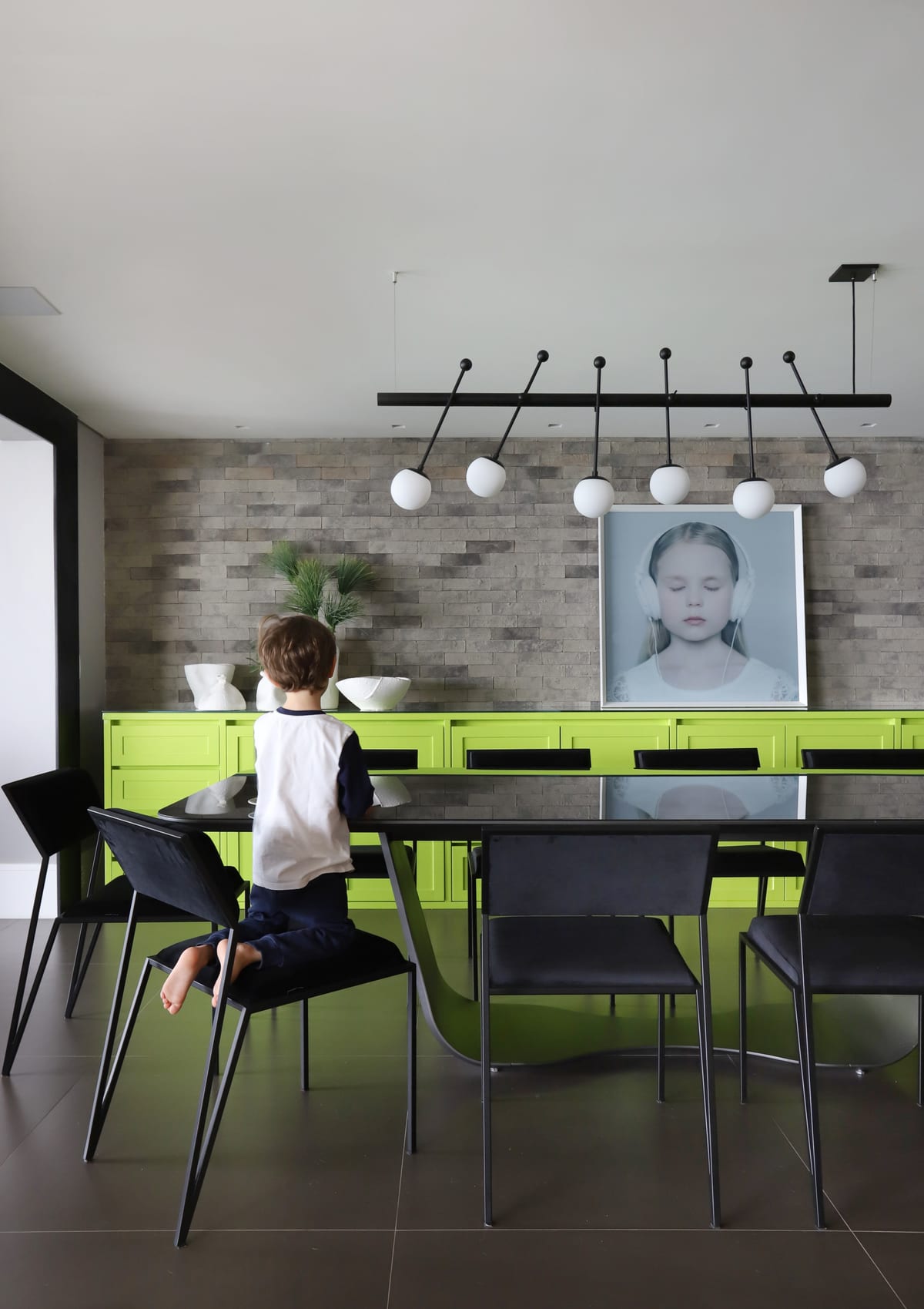 Sala de jantar com bufê verde-limão, luminária linear e parede de pedra, projeto INSIDE, acervo INSIDE