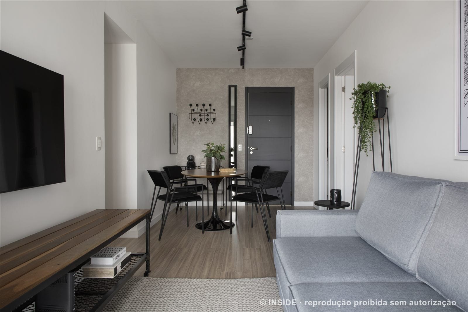 Sala de estar e jantar integradas com sofá cinza, mesa redonda de madeira e cadeiras pretas, apartamento alugado, projeto INSIDE