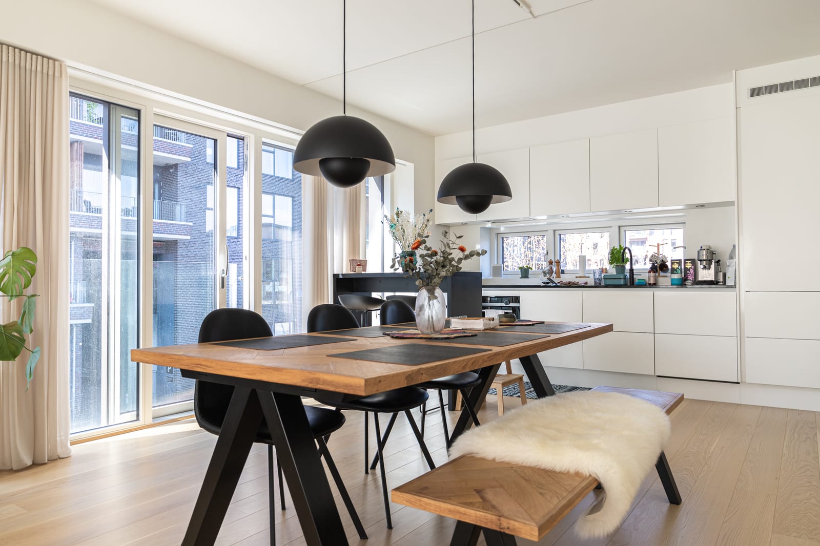 A sala de jantar com os pendentes Flowerpot e os prédios de tijolo da cidade, projeto INSIDE em Copenhague, 2022