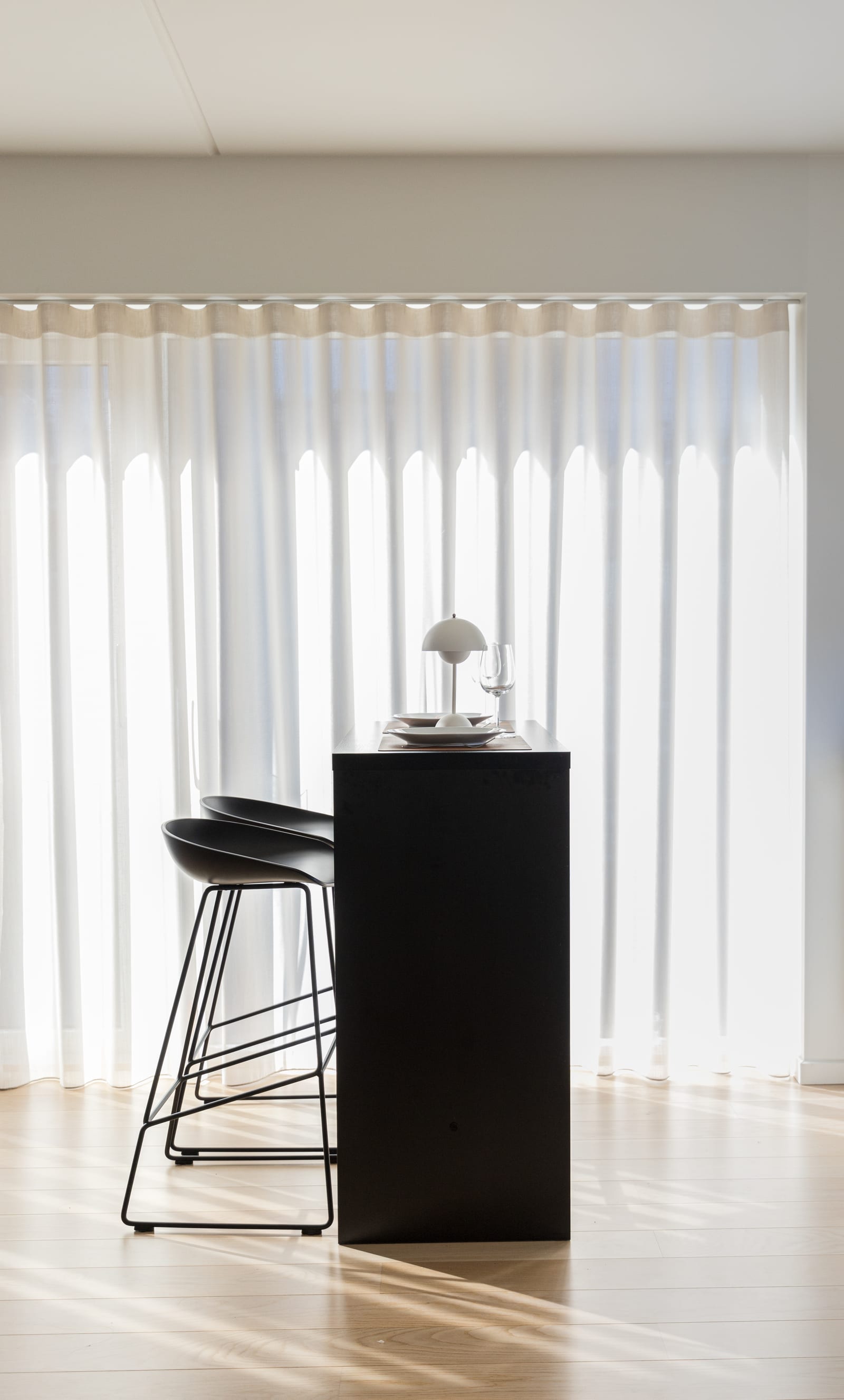 Bancada alta preta com banquetas About A Stool em contraluz, projeto INSIDE em Copenhague, 2022