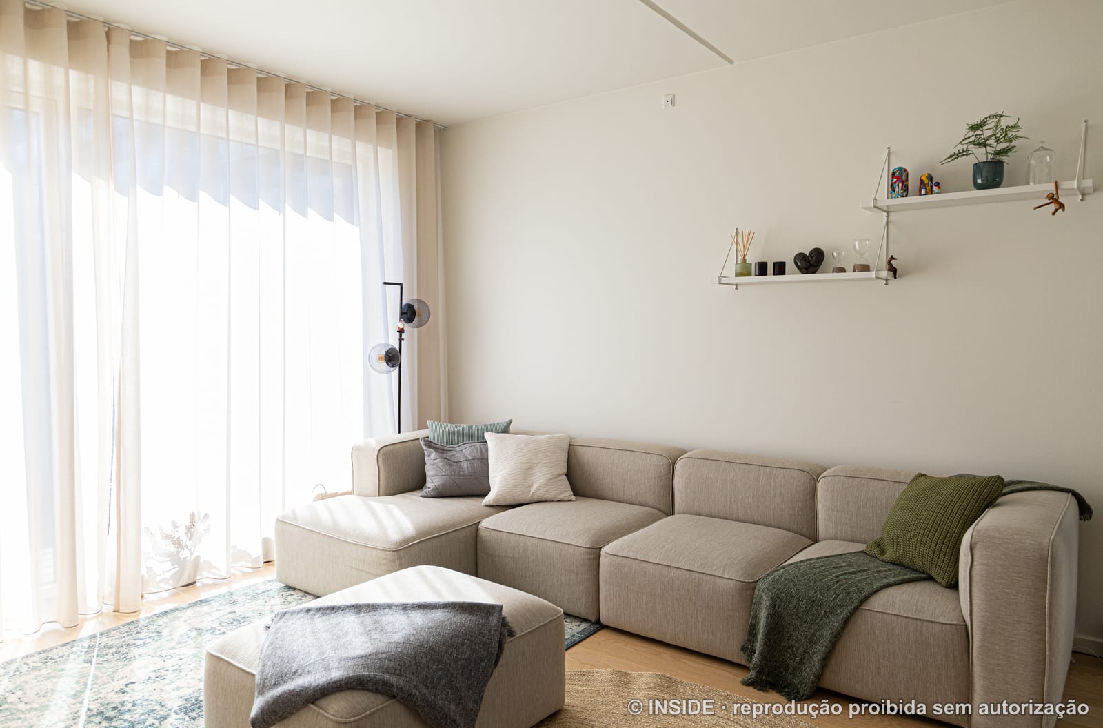 O sofá modular claro sob a prateleira suspensa de metal branco, projeto INSIDE em Copenhague, 2022