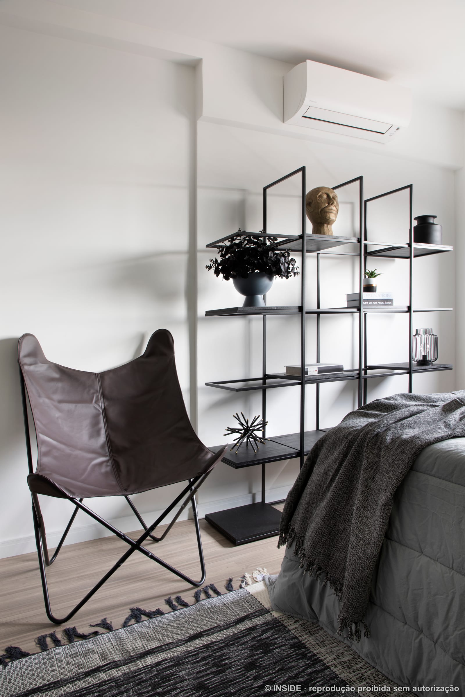 Quarto com poltrona borboleta, estante de metal e cama, apartamento alugado, projeto INSIDE