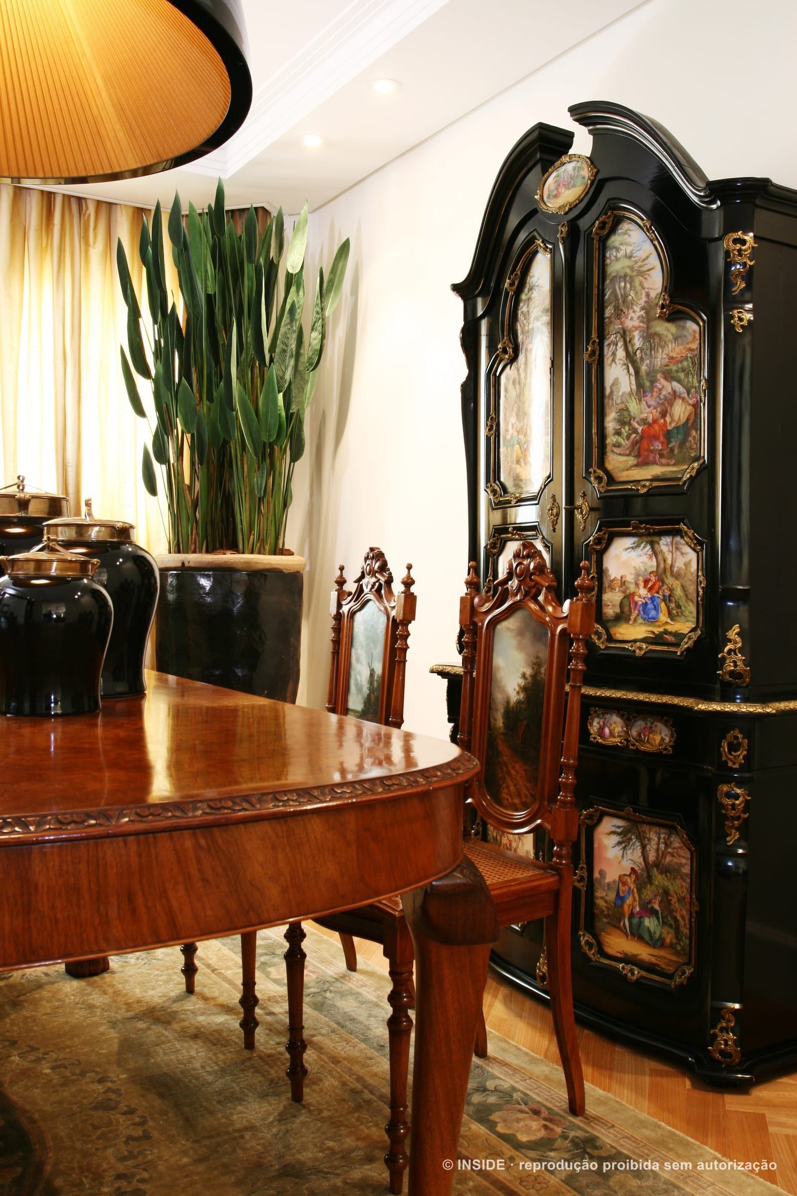 Sala de jantar com cristaleira preta laqueada de painéis pintados, mesa e cadeiras de medalhão, projeto INSIDE