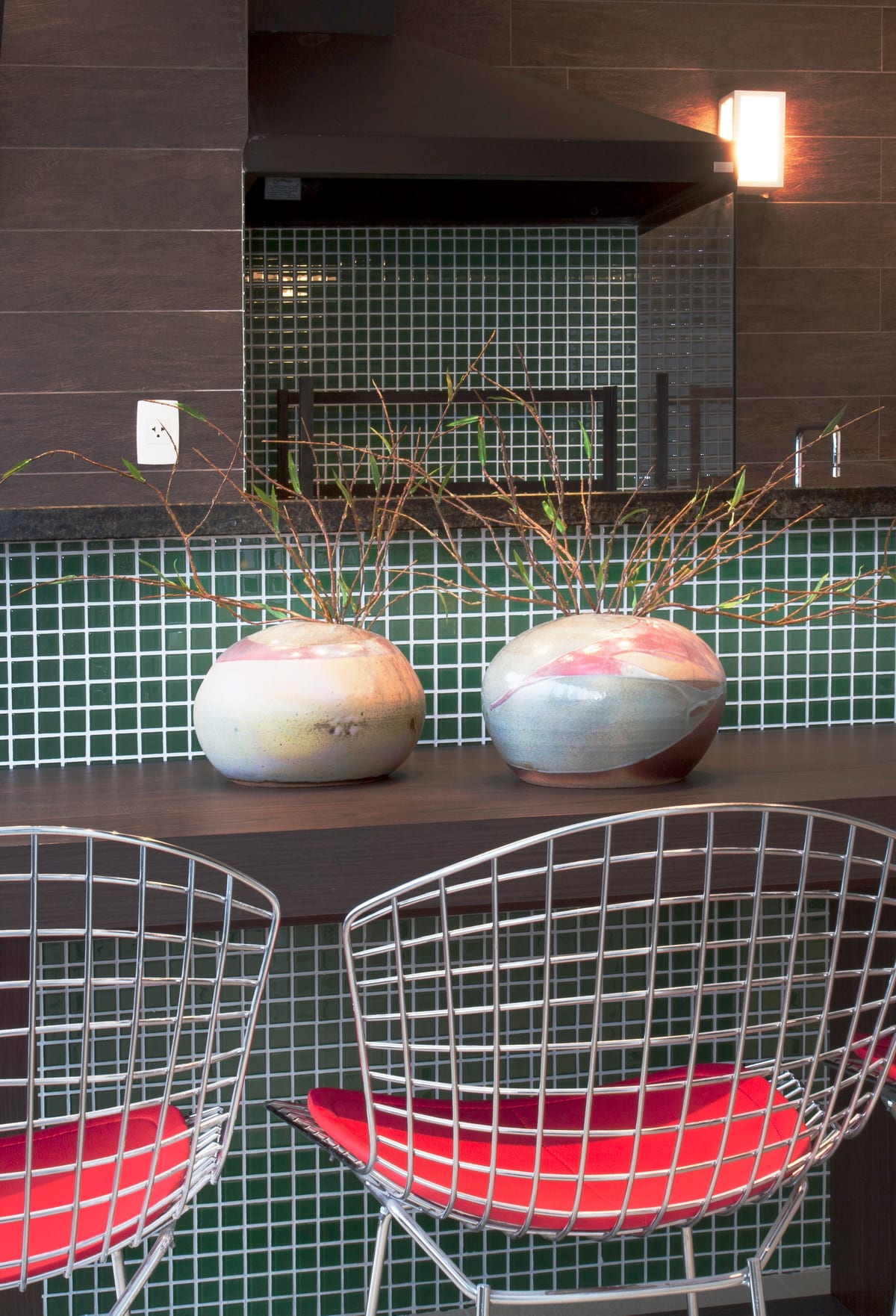 O detalhe: vasos de cerâmica com galhos sobre a bancada, na pastilha verde. Paisagismo Villa Eco, projeto INSIDE, apartamento da Rua New York, Brooklin